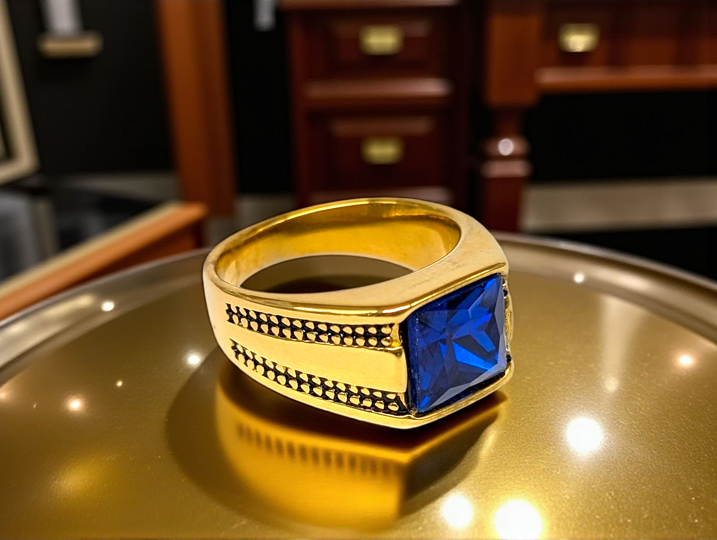 Regal Depth: Gold Ring with Blue Gemstone & Black Accents